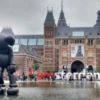 The Rijksmuseum facade with modern art sculptures and reflection in Amsterdam.