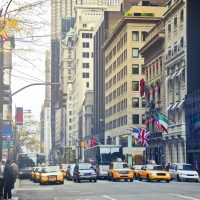 Busy New York City street with iconic taxis, buildings, and international flags